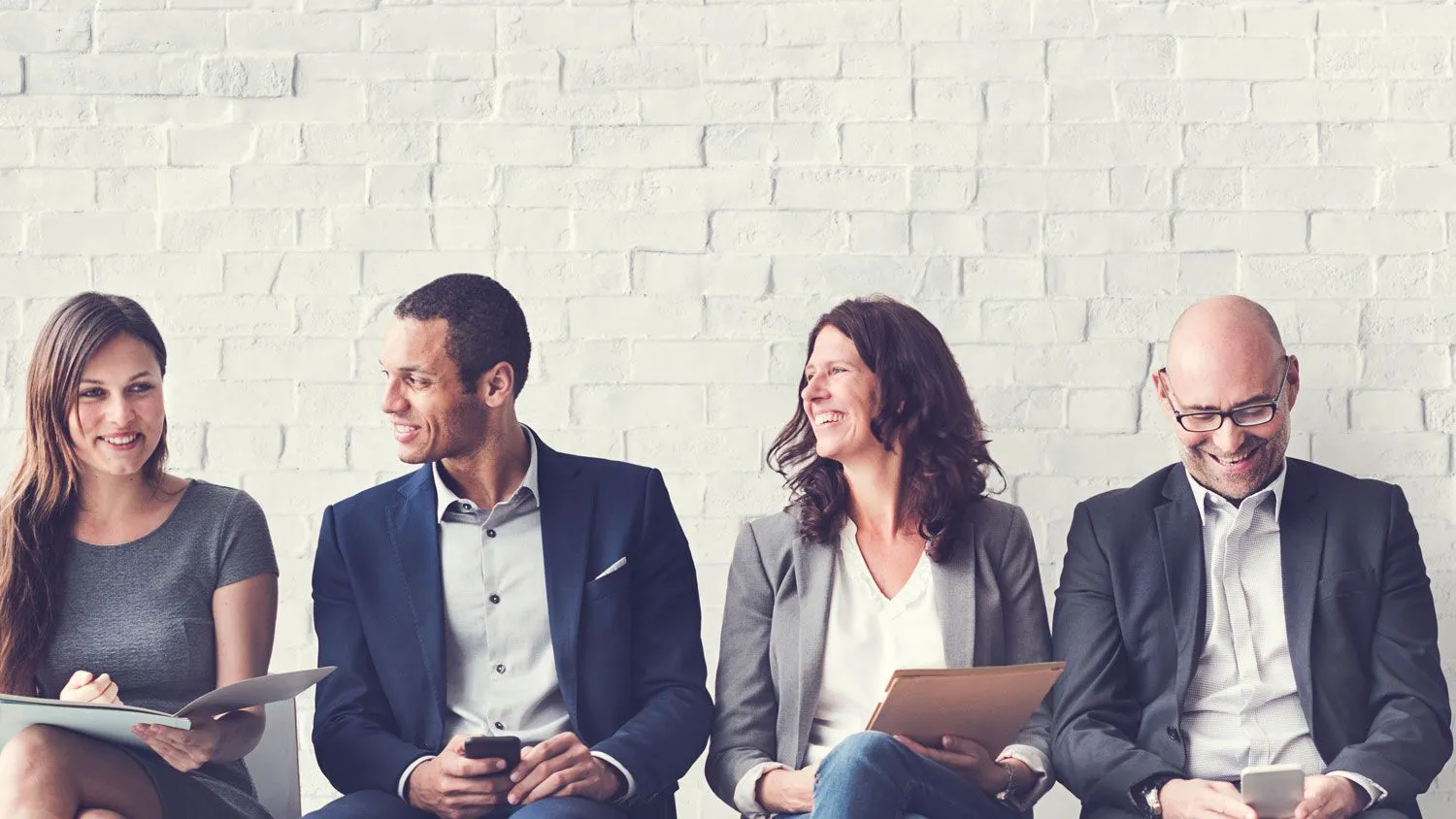 Tres consultores de recursos humanos sonriendo en una reunión corporativa de AGM